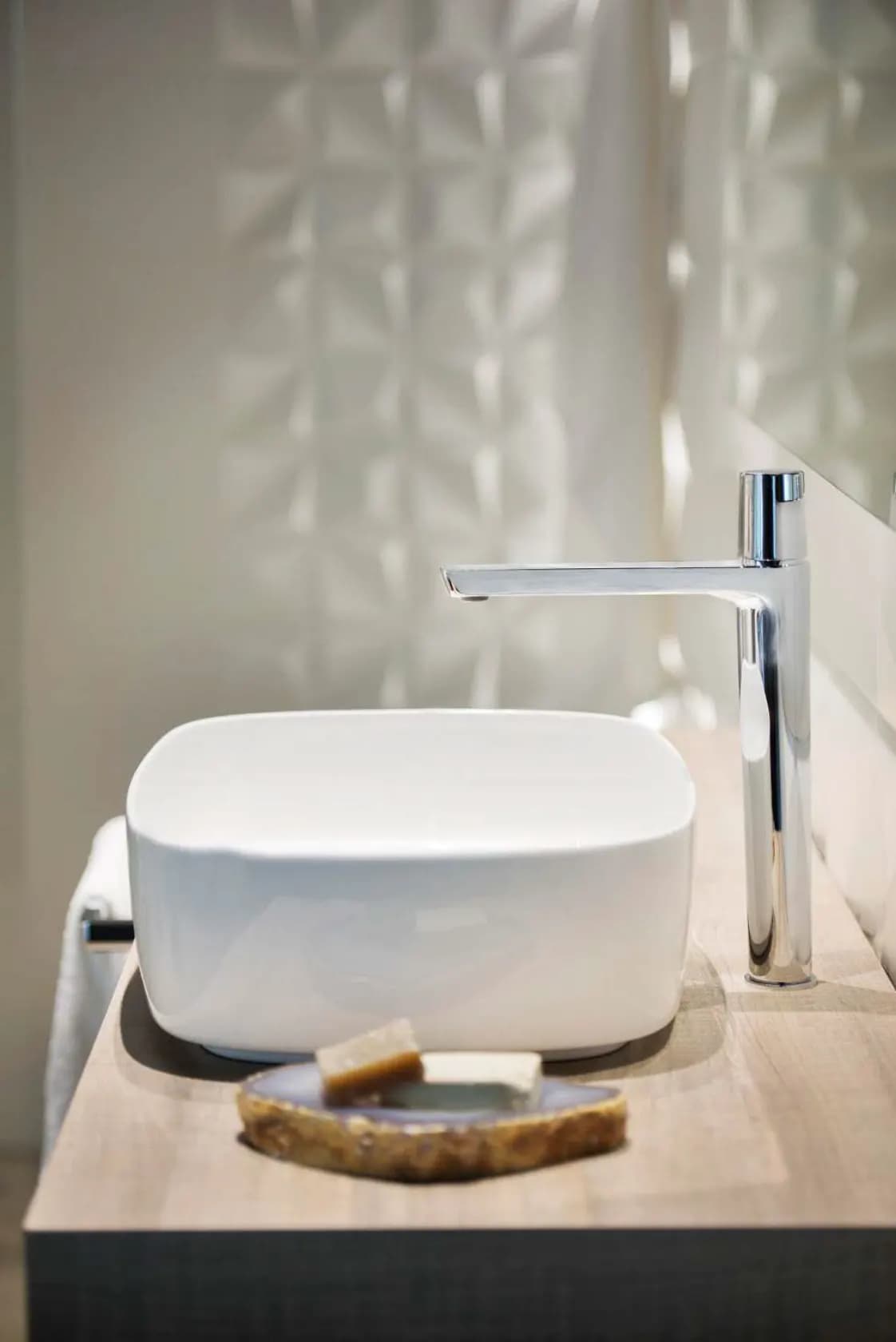 Washbasin area with the exclusive TZAR high-spout single-lever tap by Ramon Soler®. A sleek tap with plenty of personality, conveying strength and elegance and adding importance and character to the bathroom. The high-spout single-lever tap in a chrome finish is a perfect complement to the spotless white washbasin.
