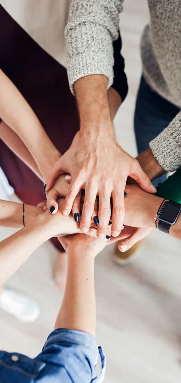 Several people's hands joined in the centre, seen from above